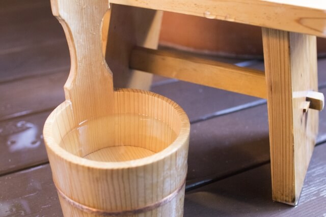 Close-up of a traditional onsen stool and wooden hand bucket
