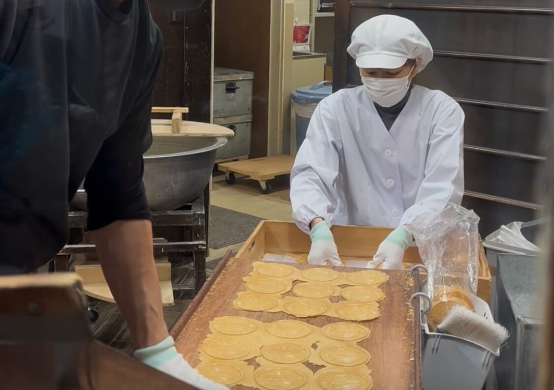 Shop staff making carbonated rice crackers at Arima Onsen