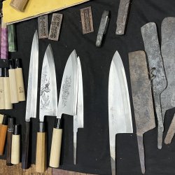 Finished Sakai knives displayed alongside partially forged blades