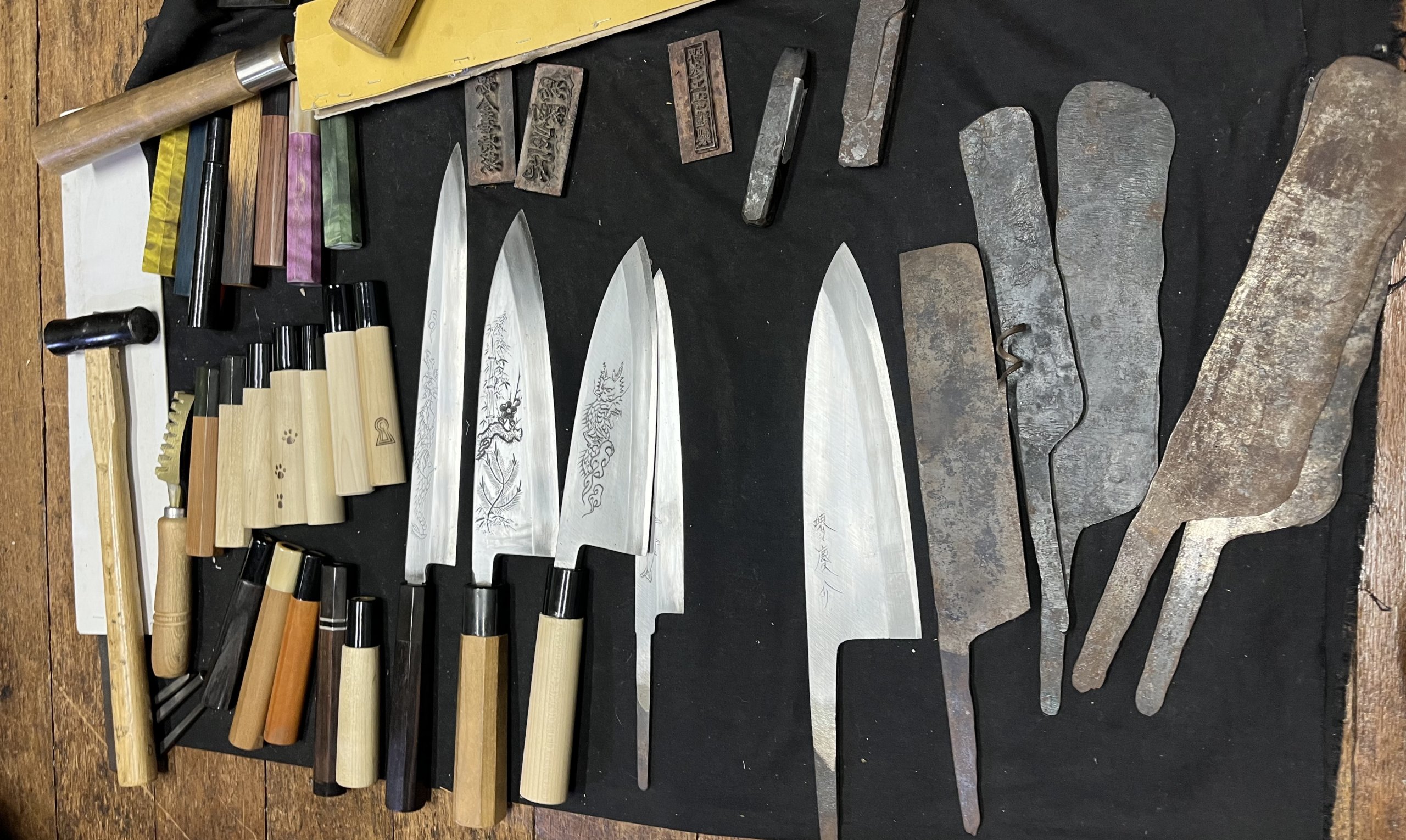 Finished Sakai knives displayed alongside partially forged blades