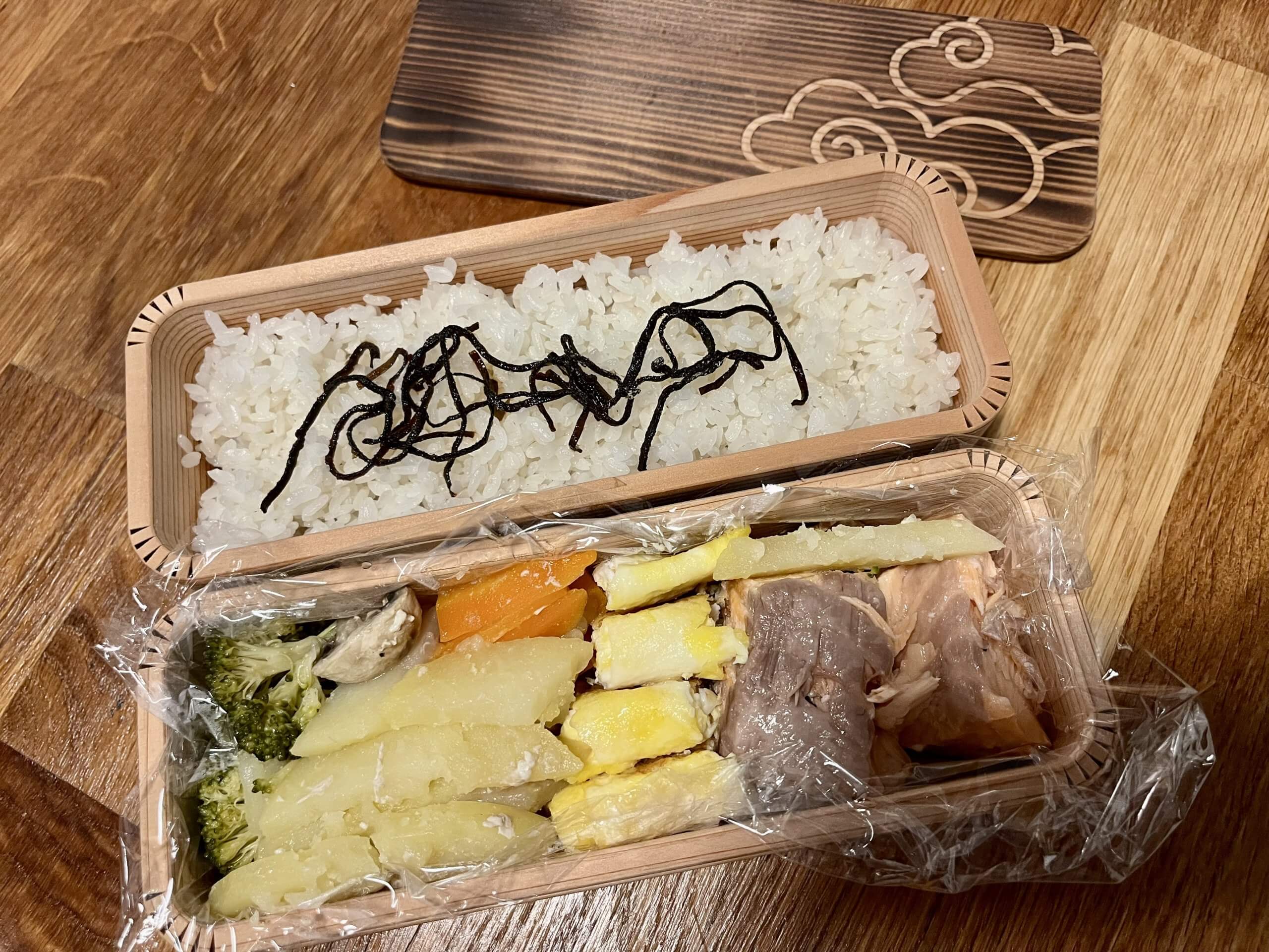 traditional two-tier wooden bento box with rice and side dishes