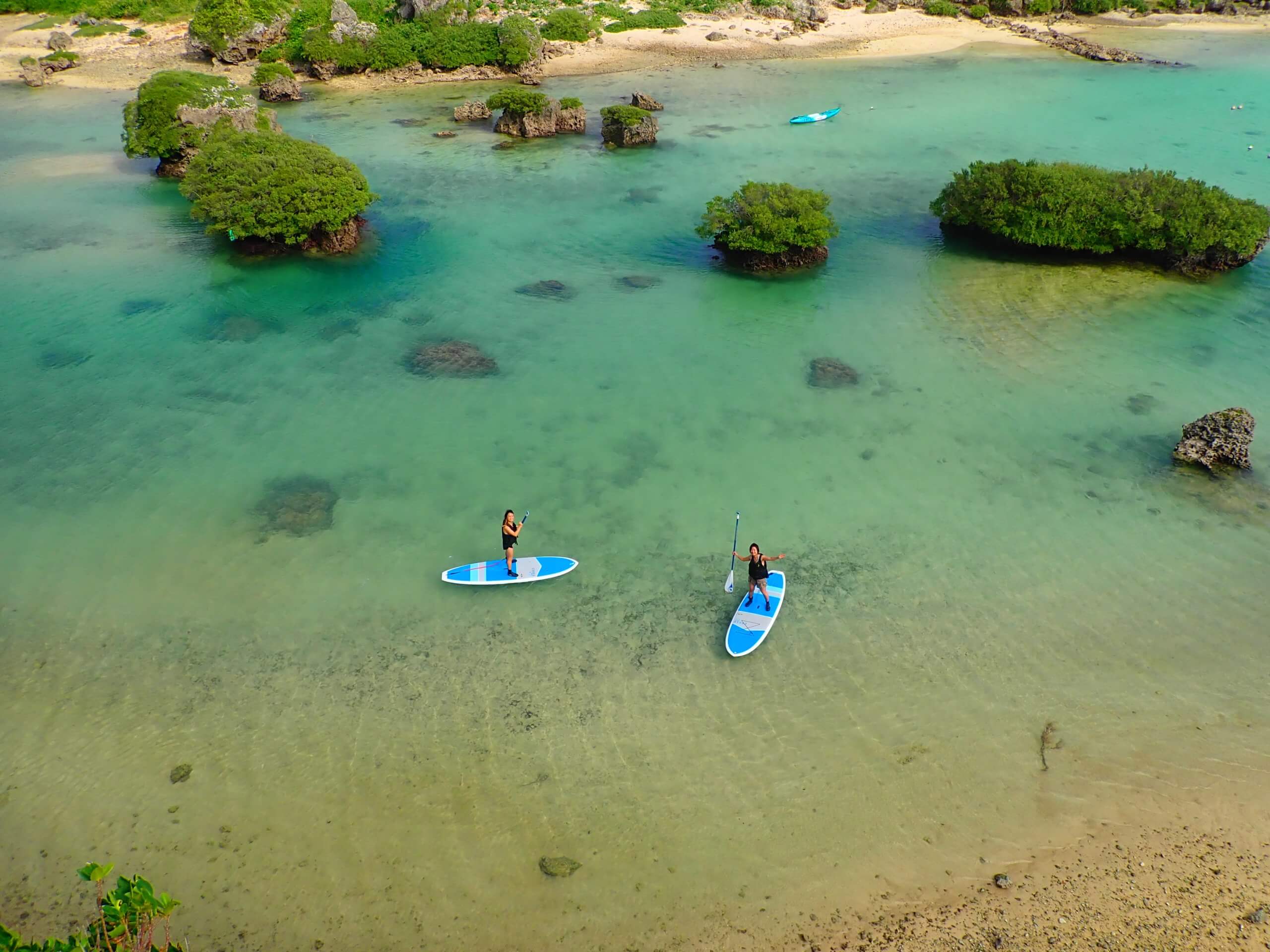 Person paddleboarding on clear blue water in Miyako Island, Okinawa