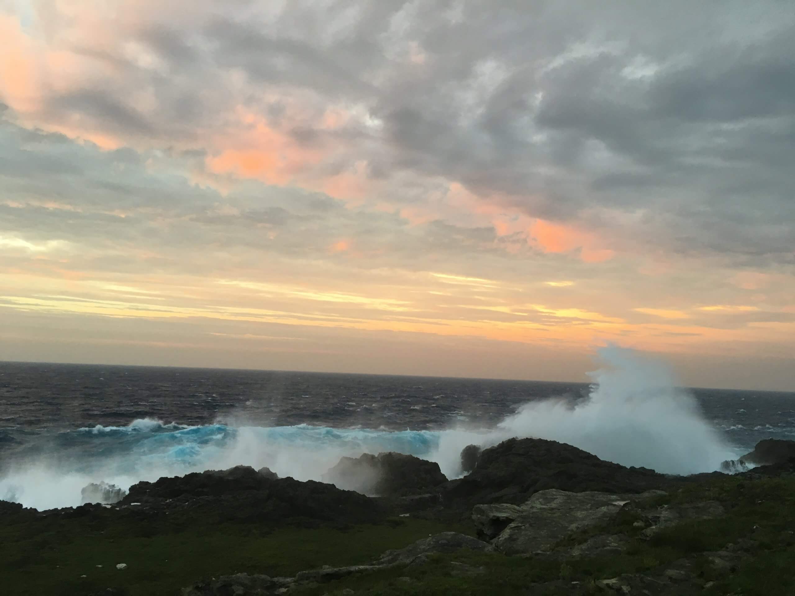 Rough ocean waves hitting rocky cliffs on Yonaguni Island coastline